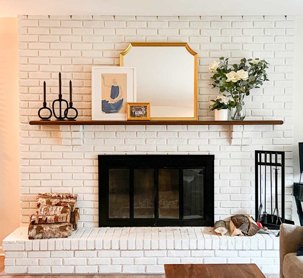 painted white brick fireplace with black grate and mirror and mantel