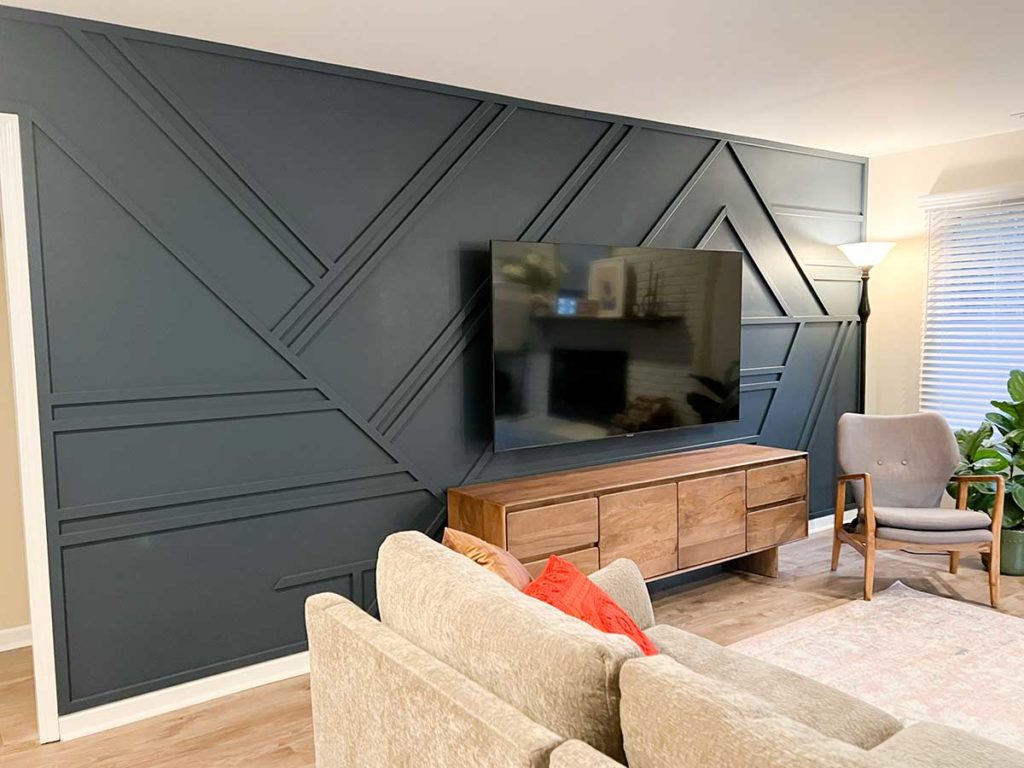 side angle of navy blue geometric accent wall with large tv