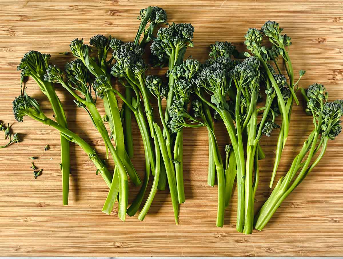 fresh broccolini spread out on cutting board
