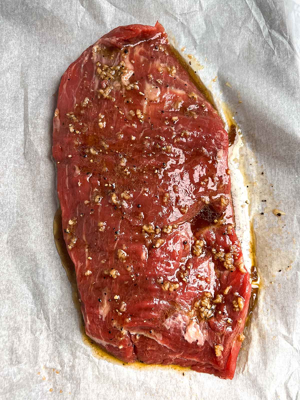 marinaded flank steak on parchment paper