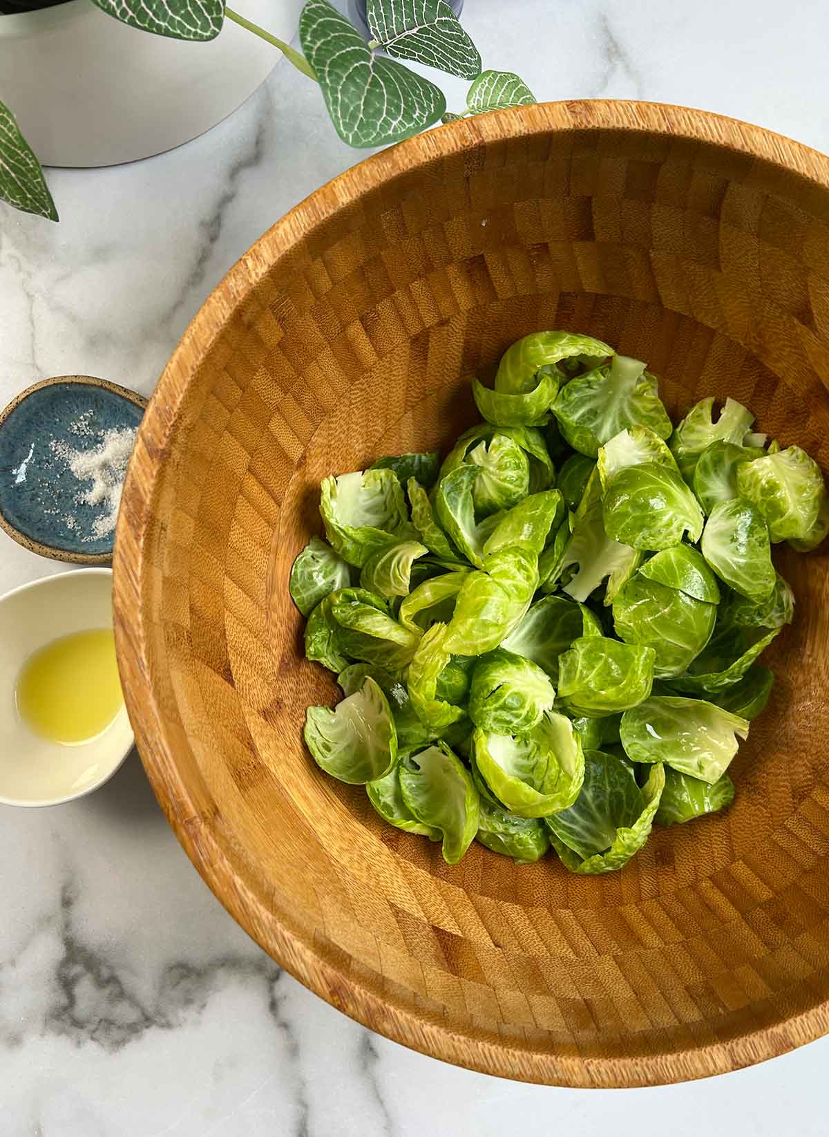brussels sprouts in wood bowl with olive oil and salt